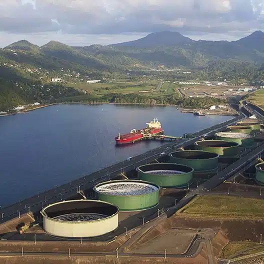 oil and gas tanker ship docking at a terminal in front of a mountain landscape