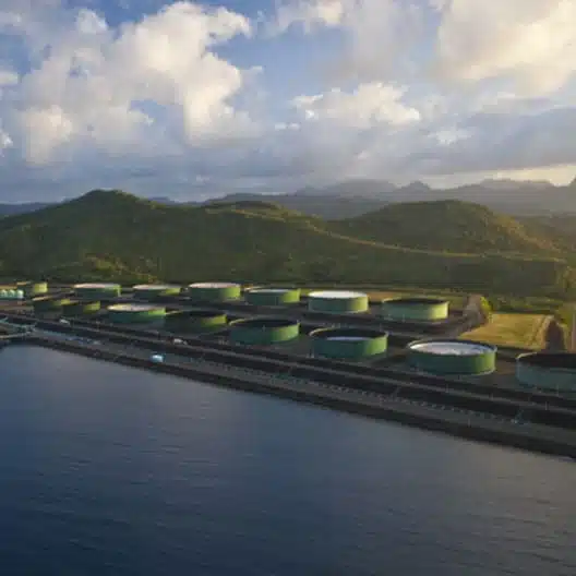 aerial view of an oil and gas port terminal facility on the coast with mountains behind